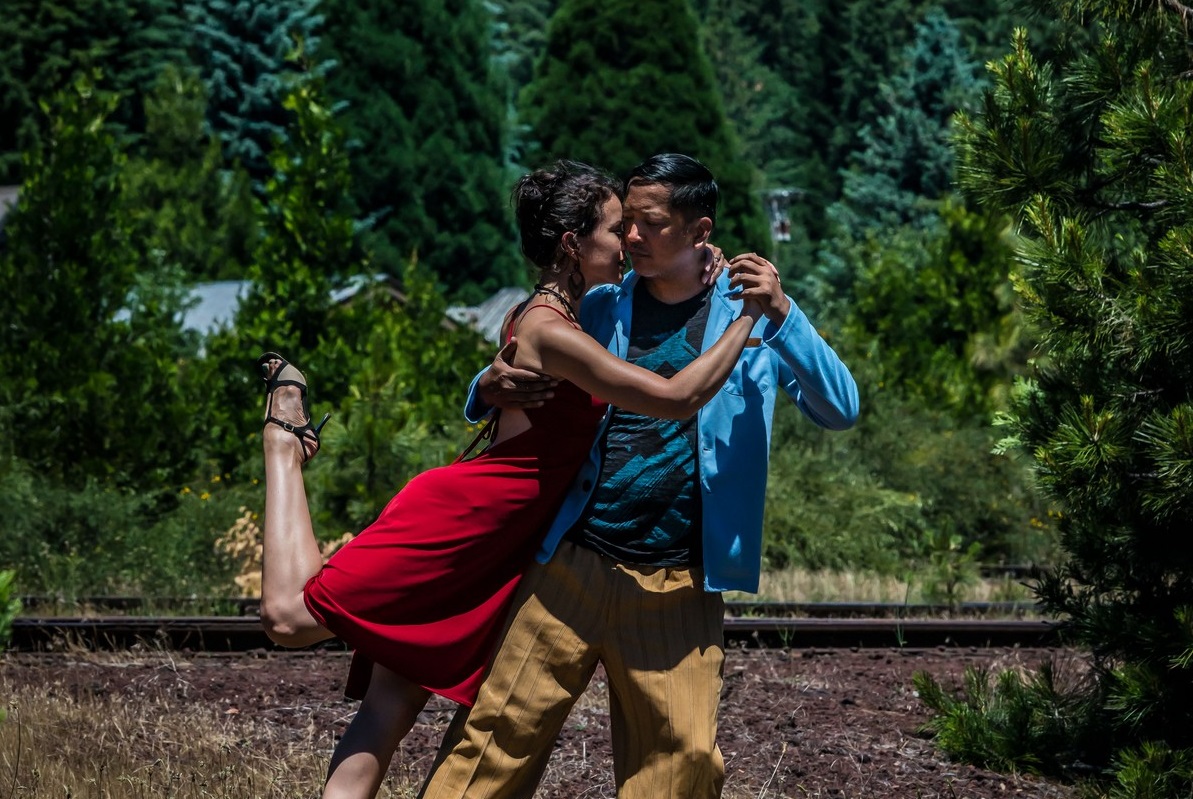 Couple dancing Argentine tango outdoors in a close embrace, showing the balance health benefits of tango